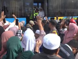 Meski Diguyur Hujan, Keluarga Serbu Bus Bawa Jemaah Haji di Ternate